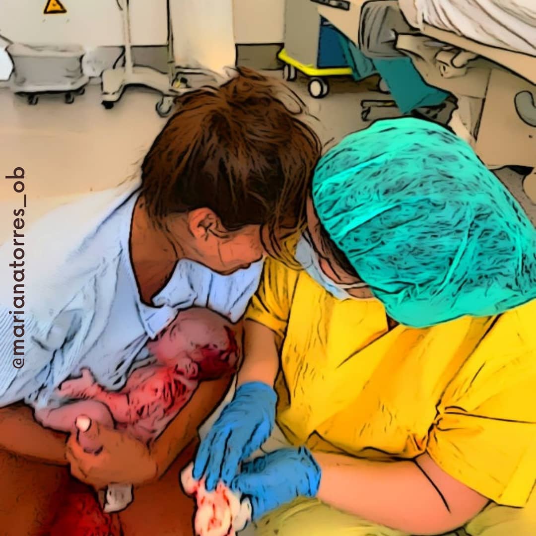 mulher acabada de parir com bebe nos braços proxima da obstetra
